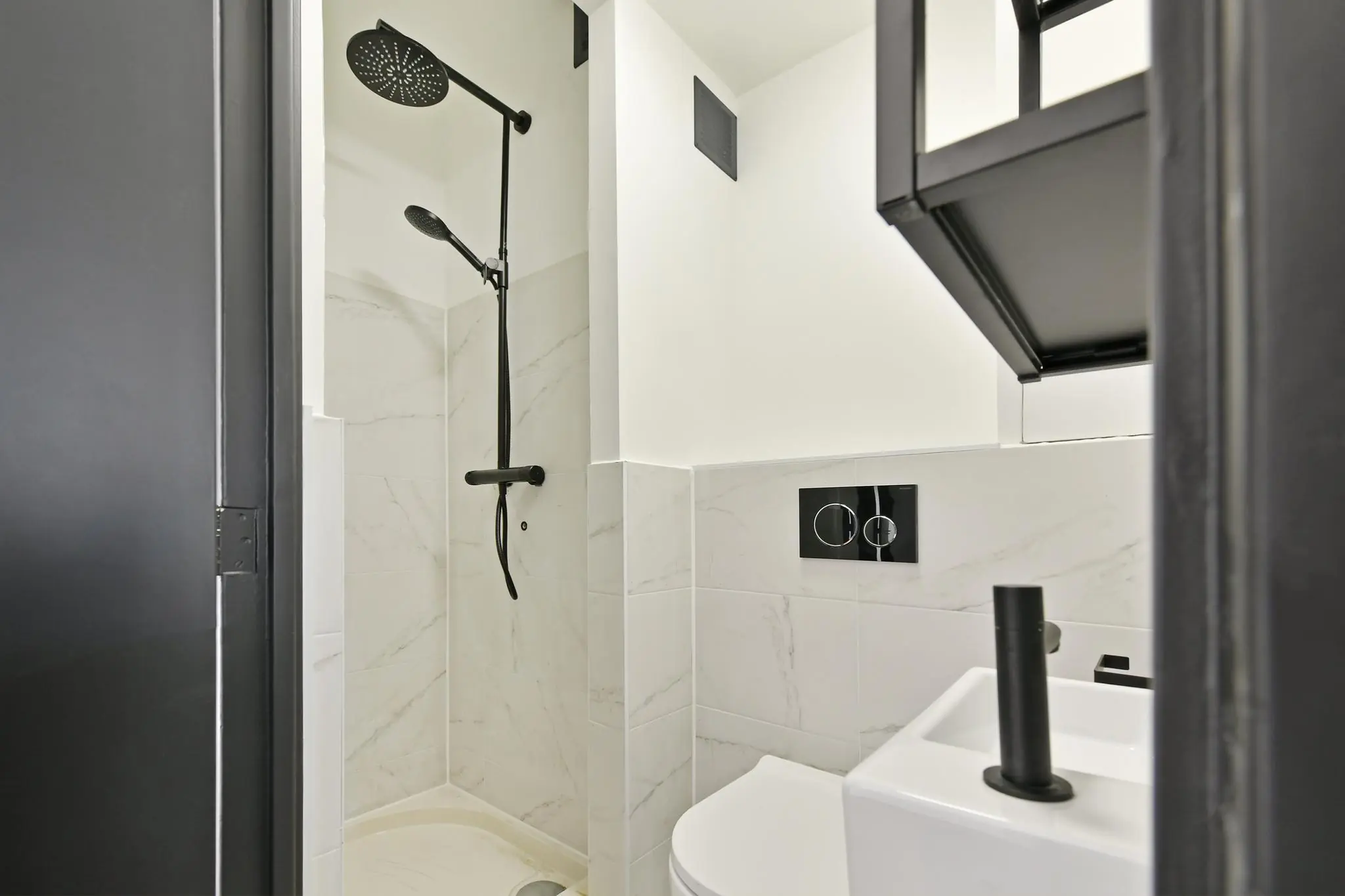 Moderne badkamer met een zwarte regendouche, hangtoilet en compact wastafelmeubel aan de Cornelis Dopperkade.